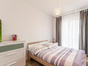 biała sypialnia z łóżkiem i oknem w obiekcie Apartament Rybacka 12A/68, Kołobrzeg w Kołobrzegu