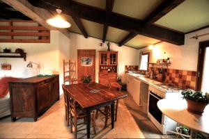 a large kitchen with a wooden table in it at Lespine-10 min Caverne Pont d'Arc in Lagorce