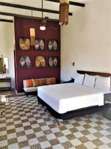 een slaapkamer met een groot bed en een bank bij Hotel Urban in Mérida