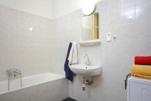 a white bathroom with a sink and a bath tub at Blue Rose Apartment in Budapest