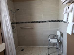 y baño con ducha y silla. en Sunset Inn Historic District St. - St. Augustine, en St. Augustine