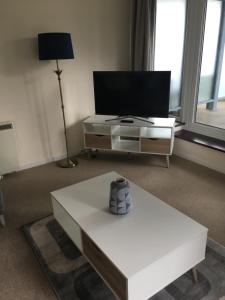 a living room with a tv and a white coffee table at Blue Sky Apartments@The Centrium, Woking in Woking