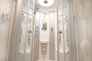 a bathroom with a shower and a phone in it at White Luxury Penthouse in City Centre in Amsterdam