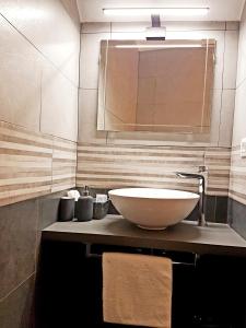 a bathroom with a bowl sink and a mirror at Moro Dal Castel - Appartamento Al Moro in Castelnuovo del Garda