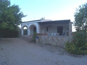une petite maison blanche avec un mur en pierre dans l'établissement Villetta Sakapo', à Corigliano dʼOtranto