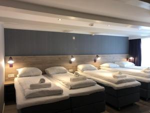 a room with three beds with white pillows on them at Facade Hotel Amsterdam in Amsterdam