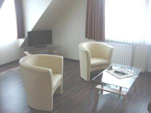 a living room with two chairs and a table at Hotel Zur Sonne in Kirchhain