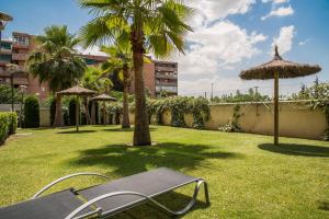a park with a bench and some palm trees at EnjoyGranada LUJO Piscina y Parking in Granada