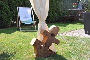 a wooden cross in the grass next to a chair at Fala Dziwnow in Dziwnów