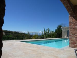 a swimming pool in a yard with a brick building at La Corte Di Langa in Albaretto Della Torre 