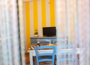 a dining room with a table with chairs and a television at Villalba in Balestrate