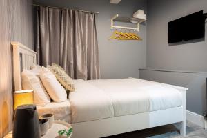 a bedroom with a white bed and a television at REM Hotel in Manchester