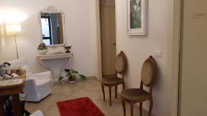 a bathroom with two chairs and a sink and a mirror at Atelier Cosseria in Florence