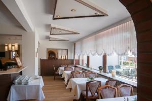 een eetkamer met tafels en stoelen en een raam bij Hotel Elbblick in Geesthacht