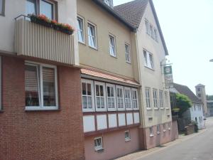 Kirchhain的住宿－Hotel Zur Sonne，砖砌的建筑,上面有窗户和时钟