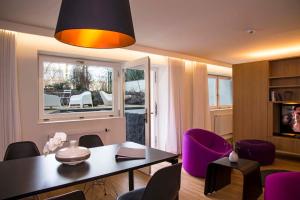 ein Wohnzimmer mit einem Tisch und lila Stühlen in der Unterkunft Key Inn Appart Hotel Parc de Merl in Luxemburg (Stadt)