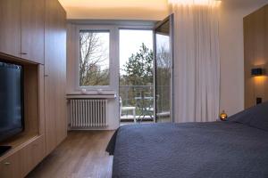 una camera con letto, TV e balcone di Key Inn Appart Hotel Parc de Merl a Lussemburgo