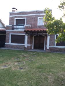 ein Backsteinhaus mit einem großen Hof davor in der Unterkunft Habitación Gabriela Mistral in Colonia del Sacramento