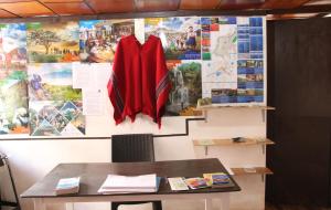 a red cape is hanging on a wall at Hospedaje Los Ponchos in Otavalo