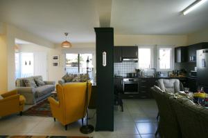 een keuken en een woonkamer met een gele stoel bij Villa Carmel in Ayia Napa