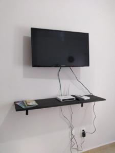 a flat screen tv on a black shelf on a wall at Playa del Carmen in Playa del Carmen