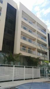 a large building with palm trees in front of it at Mediterrâneo 507 - Todo Equipado, Ar Condicionado, Churrasqueira na Varanda, Internet Fibra 600MB, Estacionamento Grátis in Cabo Frio