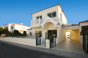 a white house with a fence and a driveway at Villa Carmel in Ayia Napa