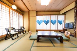a room with a table and chairs and hearts on the windows at Yamadaya Ryokan in Kyoto