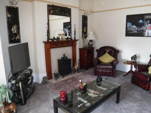 a living room with a fireplace and a tv at Camelot Hotel - Couples Only in Blackpool