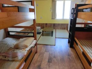 a room with two bunk beds and a desk at 善き羊飼いの舎 in Fukuoka