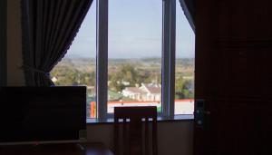 een kamer met een raam, een bureau en een monitor bij Hotel Nguyên Phước in Pleiku