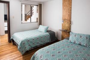 a bedroom with two beds and a window at AlterNative Hostels in Cuenca