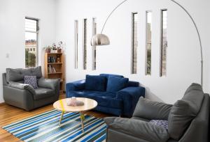 a living room with two blue couches and a table at AlterNative Hostels in Cuenca