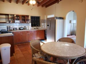 a kitchen with a table and a refrigerator at Little Indigo Apartments in Mafolie