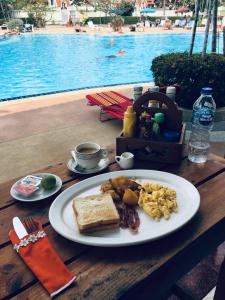 a plate of breakfast food on a table near a pool at B&B View Talay 1B by Franco Jontiem in Pattaya South
