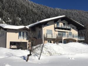 dom w śniegu przed górą w obiekcie Ferienwohnung Windhof w mieście Abtenau