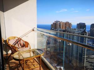 a balcony with a glass table and a view of the city at Элитная квартира в Аркадии с видом на море 26 Жемчужина in Odesa