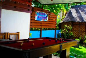 a pool table in a yard with a sign at MLK Bamboo Beachhouse in Alegria