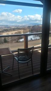 a rocking chair sitting on a porch with a large window at Widokowa Osada in Międzylesie