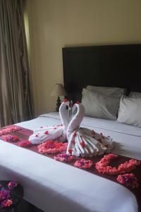 two swans made out of flowers on a bed at Suris Boutique Hotel in Kuta