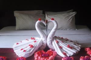 two white swans making a heart shape on a bed at Suris Boutique Hotel in Kuta