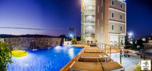 a swimming pool with lounge chairs and a building at The Elysium Residence - SHA Extra Plus in Chalong