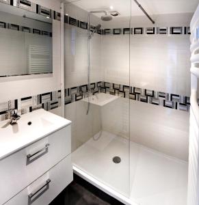 a white bathroom with a shower and a sink at BIARRITZ Victoria Surf in Biarritz