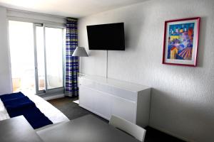 sala de estar con armario blanco y TV en BIARRITZ Victoria Surf, en Biarritz