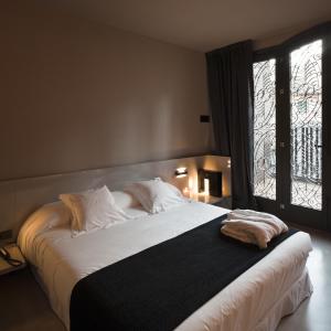 a bedroom with a large white bed with a window at Caro Hotel in Valencia