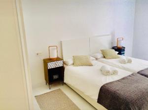 1 dormitorio con 2 camas y toallas. en Zurriola Beach, en San Sebastián