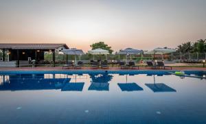 a swimming pool with chairs and umbrellas in a resort at Salcete Beach Resort in Colva
