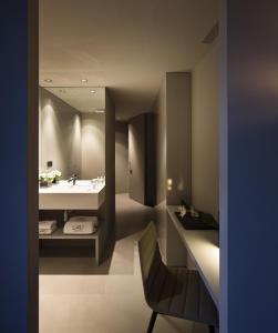 a room with a sink, chair, and a large mirror at Caro Hotel in Valencia