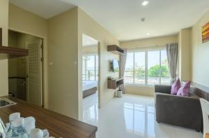 a kitchen and living room with a couch and a window at Khao Rang Place in Phuket