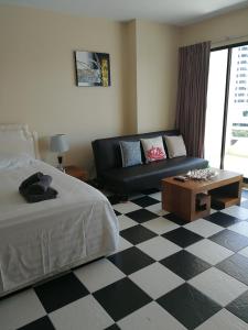 um quarto com uma cama, um sofá e um piso em xadrez em VIEW TALAY 5c STUDIO, 8 ème étage em Pattaya Sul
